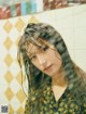 A woman with long hair standing in a bathroom.