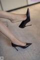 A close up of a woman's legs wearing black high heels.