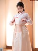 A woman in a pink and white hanbok is posing for a picture.