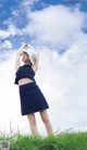 A woman standing on top of a lush green field.