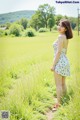 A woman standing in a field of tall grass.