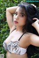 A woman in a black and white bra posing for a picture.